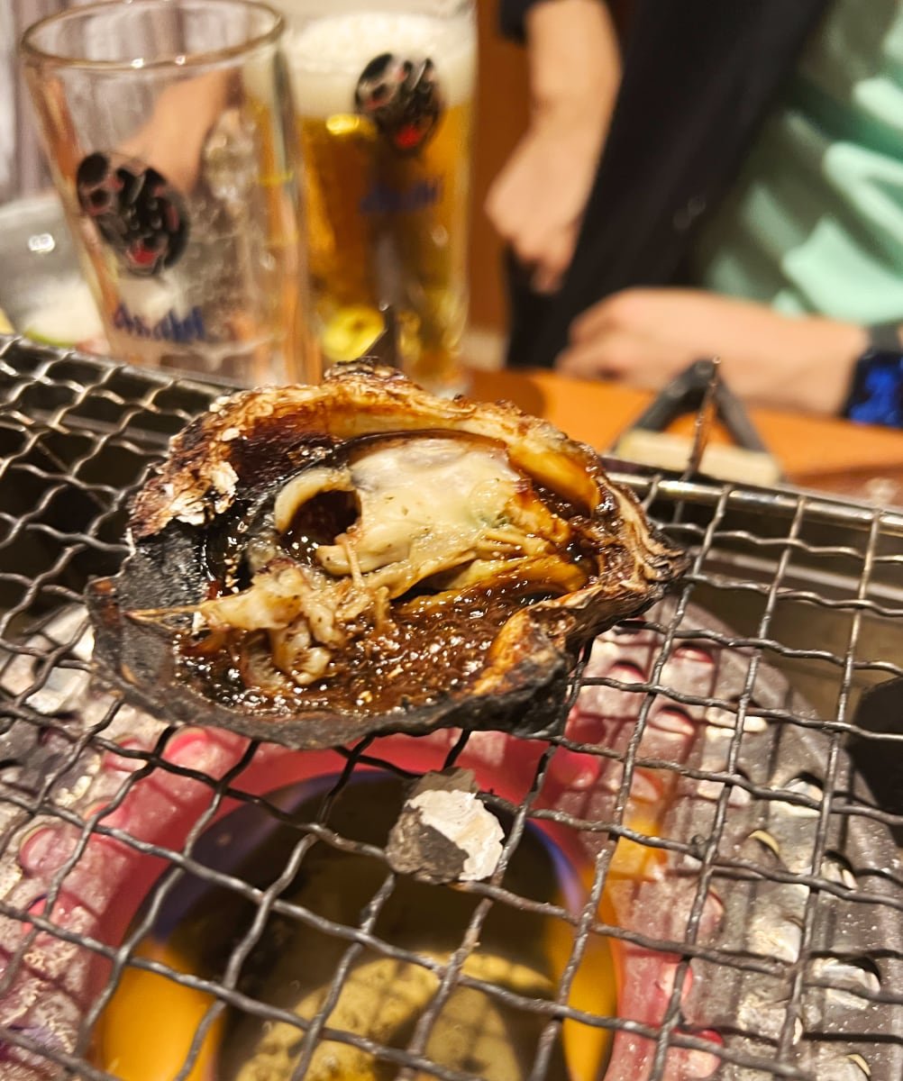 七輪に乗せた網の上で焼かれた食べ頃の焼きガキ